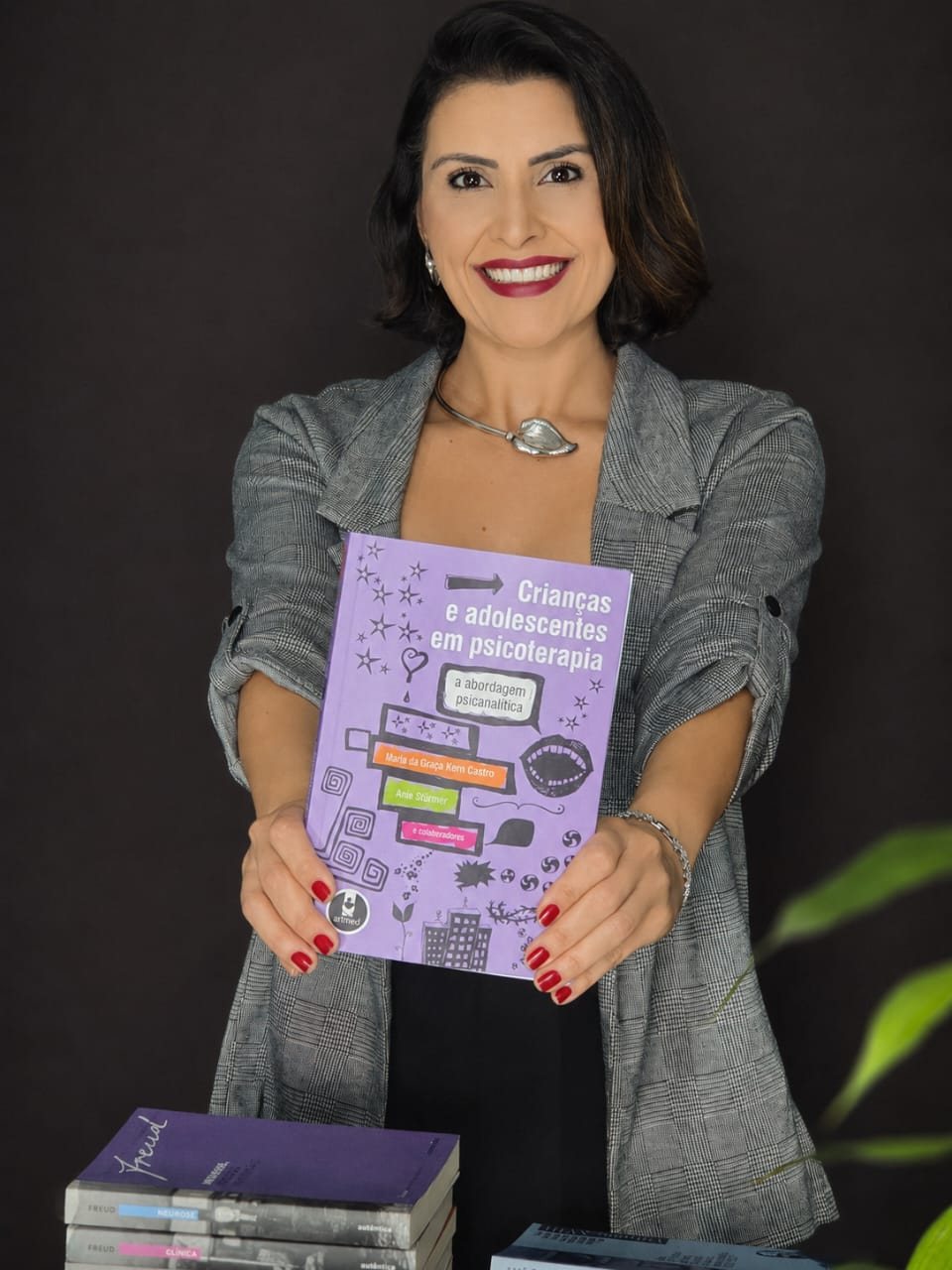 Nayara Otoni, psicóloga clínica, com um livro de psicanálise